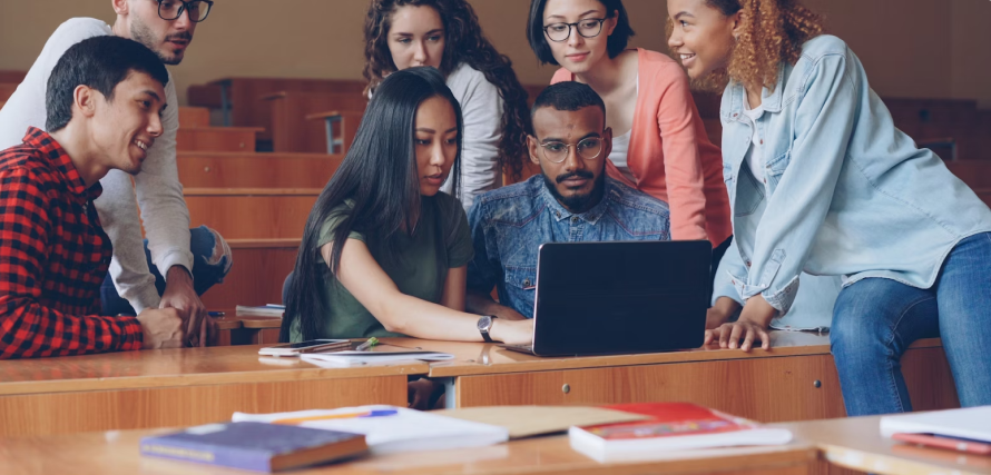 A diverse group of people collaborating around a laptop